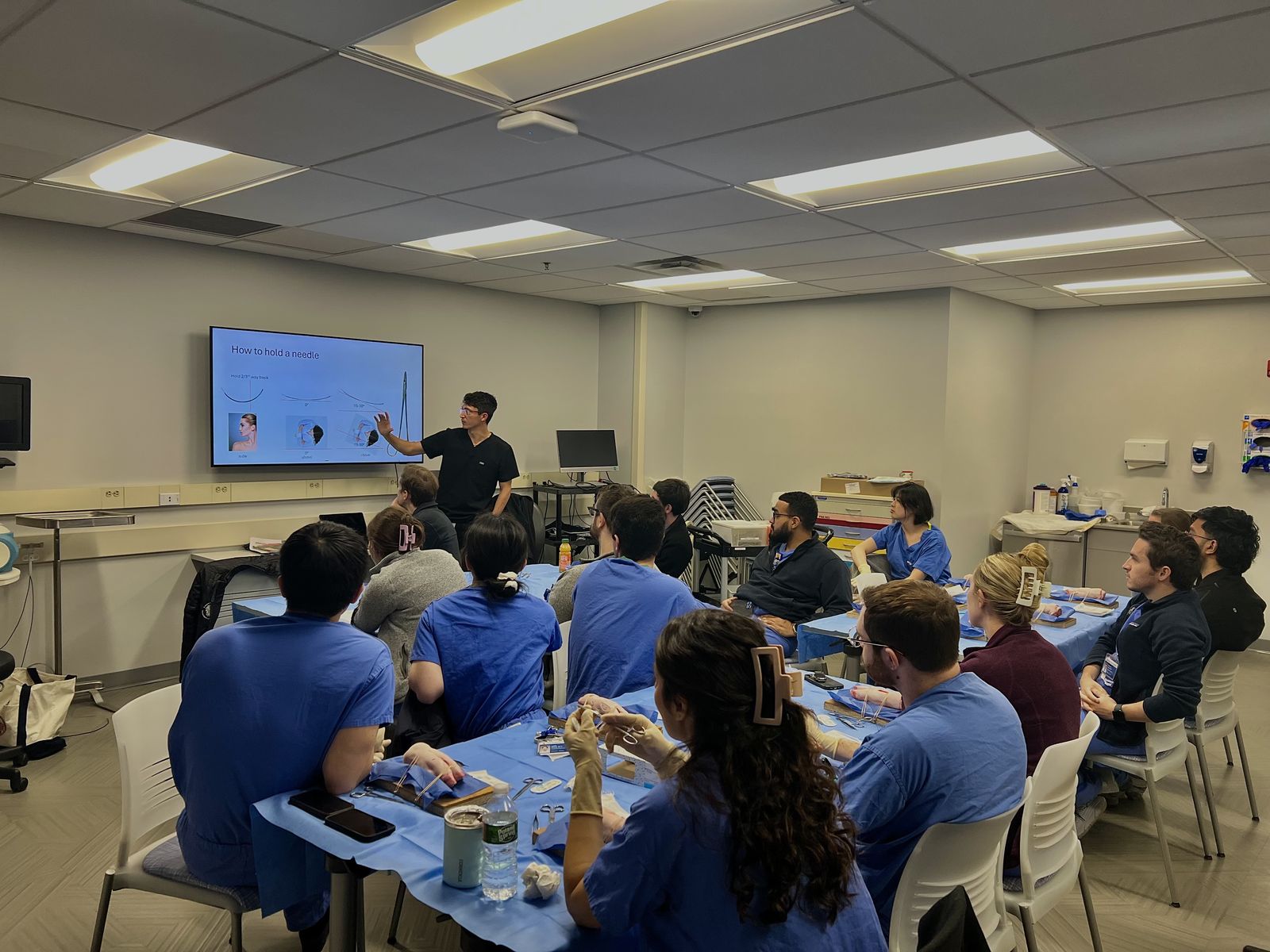 Dr. Andre Rafizadeh teaching a suturing workshop to general surgery residents, presenting needle-handling technique